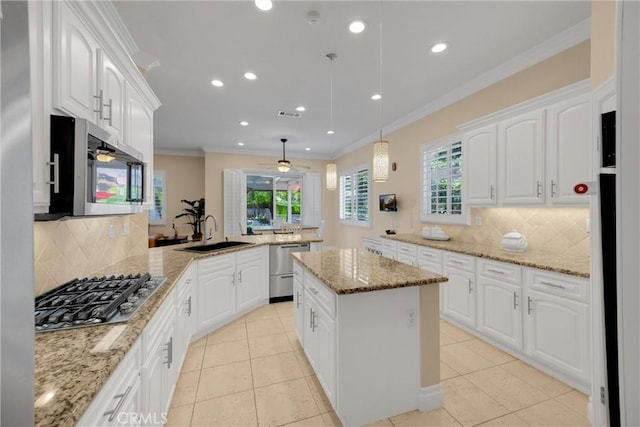 kitchen with a sink, appliances with stainless steel finishes, a peninsula, backsplash, and healthy amount of natural light
