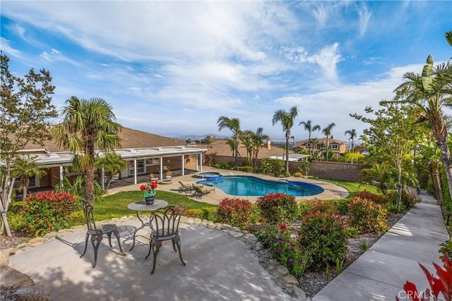 view of pool featuring a fenced backyard, a patio, and a pool with connected hot tub