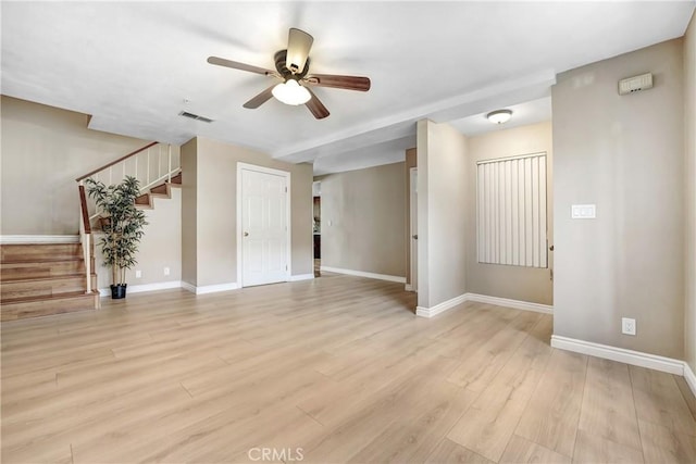 unfurnished living room featuring ceiling fan, stairway, baseboards, and light wood finished floors
