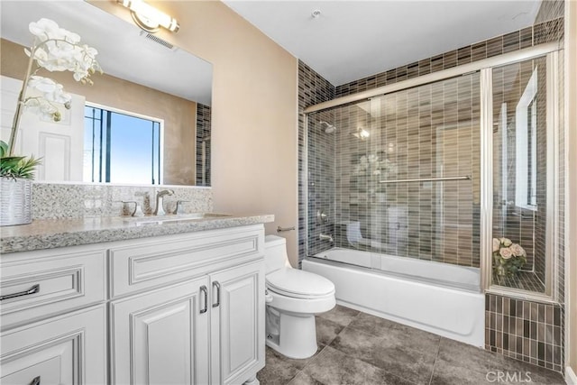 full bathroom featuring toilet, vanity, enclosed tub / shower combo, and tile patterned floors