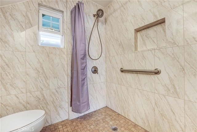 full bath featuring tiled shower and toilet