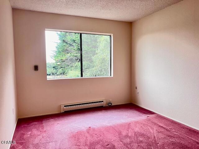 511 Cypress St Unit 4, Fort Bragg, CA 95437 - carpeted empty room with a baseboard heating unit and a textured ceiling