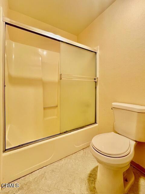 511 Cypress St Unit 4, Fort Bragg, CA 95437 - full bathroom with combined bath / shower with glass door, toilet, baseboards, and tile patterned floors
