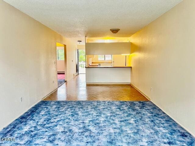 511 Cypress St Unit 4, Fort Bragg, CA 95437 - unfurnished living room with a textured ceiling, a baseboard radiator, and carpet floors
