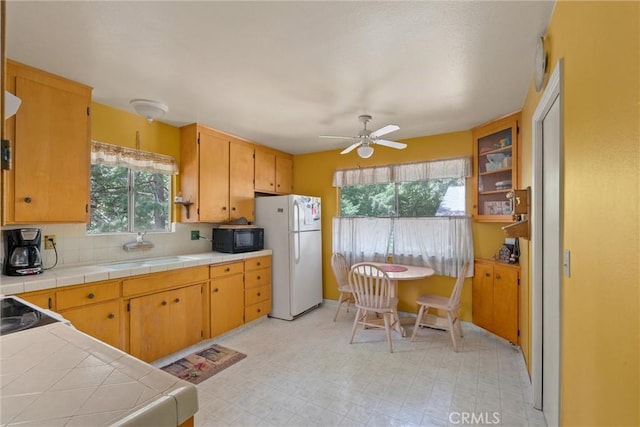 14693 Lafayette Cir, Magalia, CA 95954 - kitchen with freestanding refrigerator, black microwave, a sink, and healthy amount of natural light