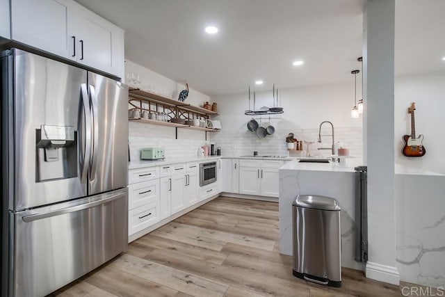 6780 Friars Rd Unit 269, San Diego, CA 92108 - kitchen featuring appliances with stainless steel finishes, a sink, tasteful backsplash, white cabinetry, and light wood-type flooring
