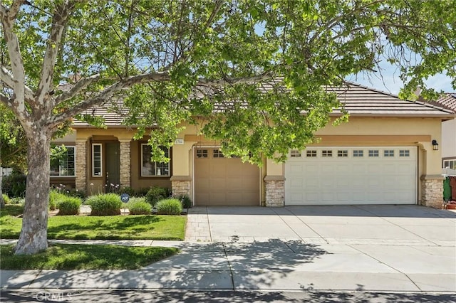 1704 Golden Way, Beaumont, CA 92223 - view of front of house with stone siding, driveway, stucco siding, and an attached garage