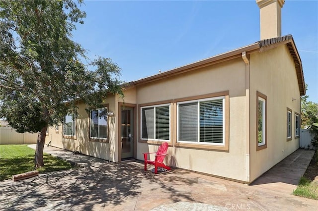 1704 Golden Way, Beaumont, CA 92223 - back of property featuring a patio, a chimney, and stucco siding