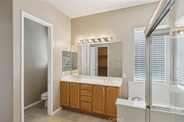 1704 Golden Way, Beaumont, CA 92223 - full bathroom featuring double vanity, toilet, tile patterned floors, and baseboards