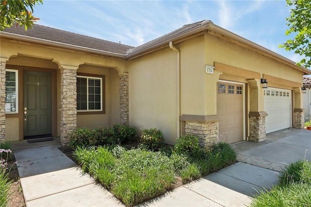 1704 Golden Way, Beaumont, CA 92223 - view of side of home featuring stone siding, an attached garage, stucco siding, and concrete driveway