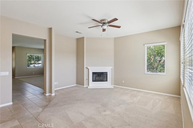 1704 Golden Way, Beaumont, CA 92223 - unfurnished living room featuring a ceiling fan, a glass covered fireplace, baseboards, and light colored carpet