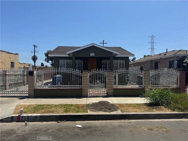 714 E 110th St, Los Angeles, CA 90059 - bungalow-style home with a gate, a fenced front yard, and roof with shingles