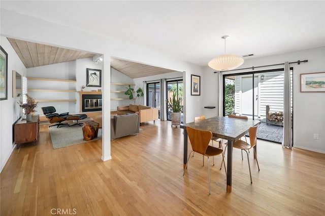 2350 Meadow St, San Luis Obispo, CA 93401 - dining space with light wood-style flooring, lofted ceiling, built in features, a glass covered fireplace, and baseboards