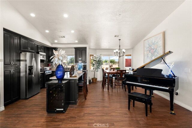 10779 Mills Rd, Apple Valley, CA 92308 - kitchen with appliances with stainless steel finishes, dark cabinetry, a center island, a chandelier, and dark wood finished floors