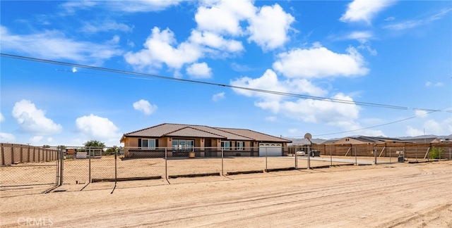 10779 Mills Rd, Apple Valley, CA 92308 - view of front of property featuring a fenced front yard, driveway, a tile roof, and stucco siding