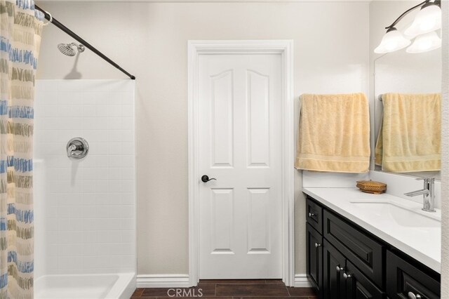 10779 Mills Rd, Apple Valley, CA 92308 - bathroom featuring a shower with shower curtain, vanity, wood finished floors, and baseboards