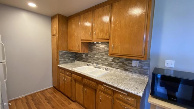 3407 Rexford St, Ventura, CA 93003 - kitchen with black microwave, tasteful backsplash, light wood-style floors, light countertops, and brown cabinetry