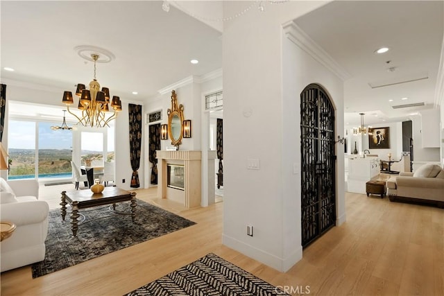 3610 Monserate Hill Ct, Fallbrook, CA 92028 - living room with a chandelier, light wood-style floors, ornamental molding, recessed lighting, and a multi sided fireplace