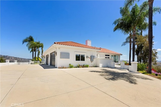 3610 Monserate Hill Ct, Fallbrook, CA 92028 - back of property featuring a chimney, a tiled roof, driveway, a garage, and stucco siding