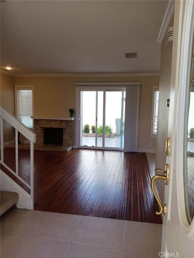 18 Goldenbush, Irvine, CA 92604 - unfurnished living room featuring wood-type flooring, ornamental molding, plenty of natural light, a fireplace, and stairs