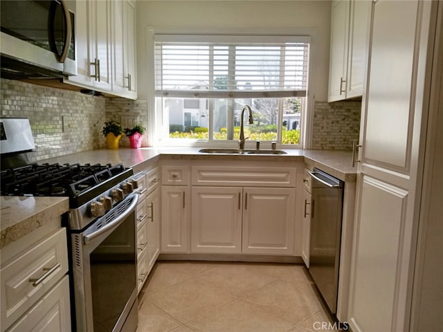 18 Goldenbush, Irvine, CA 92604 - kitchen featuring stainless steel appliances, white cabinetry, backsplash, and light tile patterned floors