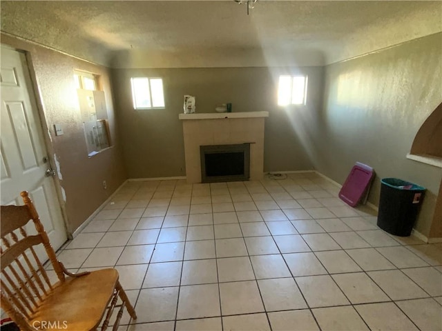 215 W 23rd St, San Bernardino, CA 92405 - unfurnished living room with a fireplace, light tile patterned floors, and a textured ceiling