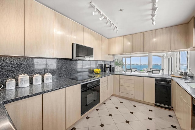 3868 Riviera Dr Unit 4A, San Diego, CA 92109 - kitchen featuring black appliances, light brown cabinetry, rail lighting, and decorative backsplash
