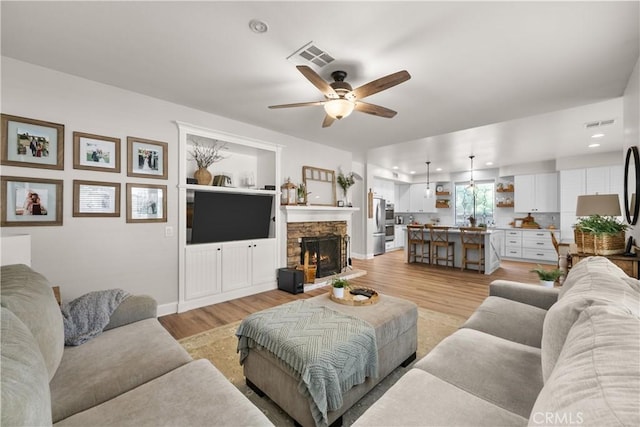 22011 Iron Horse Pl, Saugus, CA 91390 - living area featuring light wood-style flooring, ceiling fan, a stone fireplace, recessed lighting, and baseboards