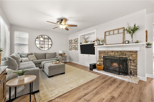 22011 Iron Horse Pl, Saugus, CA 91390 - living area with a stone fireplace, ceiling fan, wood finished floors, and baseboards