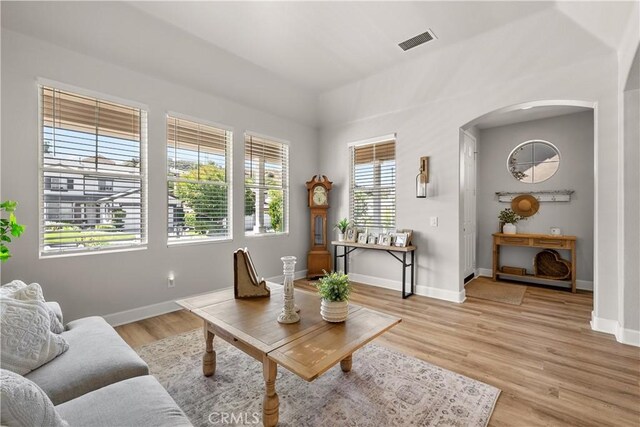 22011 Iron Horse Pl, Saugus, CA 91390 - living area featuring arched walkways, baseboards, and light wood-style floors