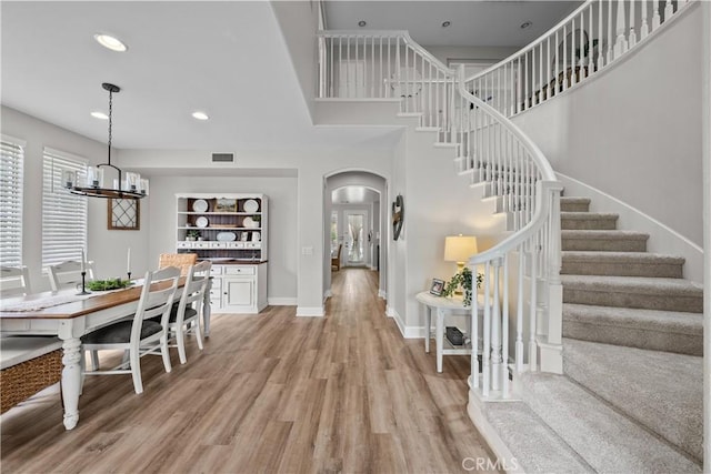 22011 Iron Horse Pl, Saugus, CA 91390 - dining space with arched walkways, stairs, light wood finished floors, a chandelier, and recessed lighting