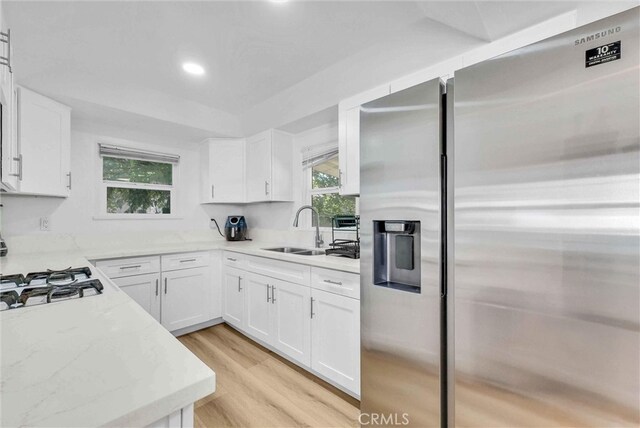 2513 Genevieve St, San Bernardino, CA 92405 - kitchen with stainless steel fridge with ice dispenser, a sink, light stone countertops, white cabinetry, and recessed lighting
