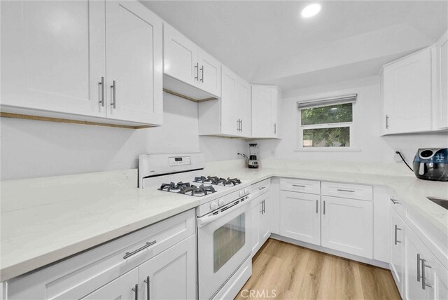 2513 Genevieve St, San Bernardino, CA 92405 - kitchen featuring white range with gas stovetop, white cabinets, light stone countertops, and recessed lighting
