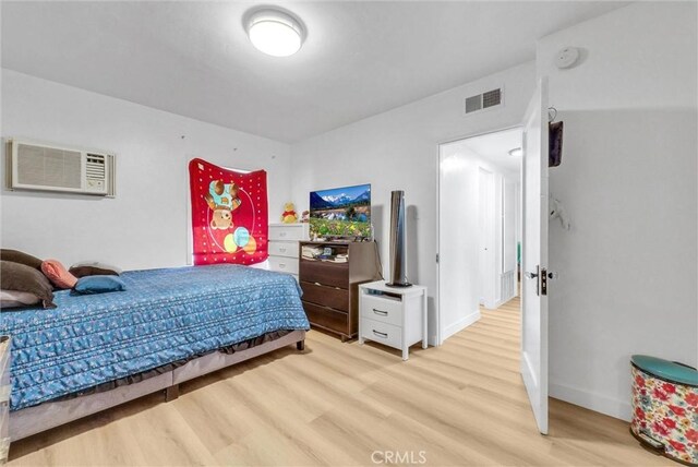 2513 Genevieve St, San Bernardino, CA 92405 - bedroom featuring light wood-type flooring, a wall mounted air conditioner, and baseboards