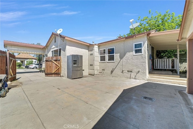 2513 Genevieve St, San Bernardino, CA 92405 - rear view of house with a gate, stucco siding, and a patio