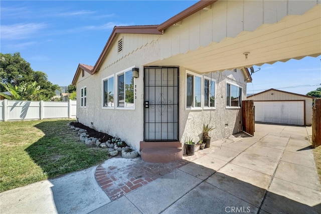 2513 Genevieve St, San Bernardino, CA 92405 - view of exterior entry featuring stucco siding, a detached garage, and a patio area