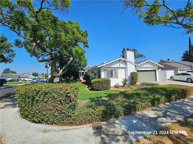 4126 Sebren Ave, Lakewood, CA 90713 - view of property exterior featuring a garage, a chimney, a lawn, concrete driveway, and stucco siding