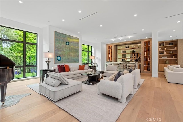 living room featuring wood finished floors, recessed lighting, and built in shelves