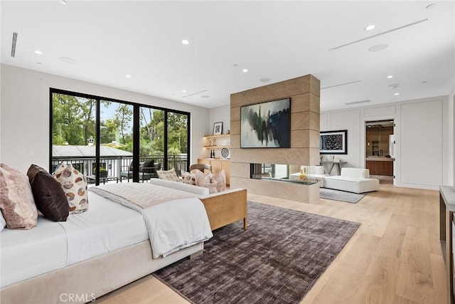 bedroom featuring access to exterior, light wood finished floors, and recessed lighting