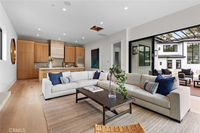 living room featuring light wood-style flooring, recessed lighting, and baseboards