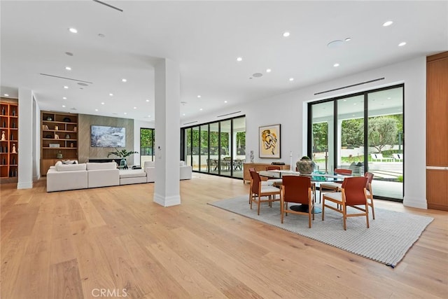 dining space featuring recessed lighting, light wood-type flooring, built in shelves, and baseboards