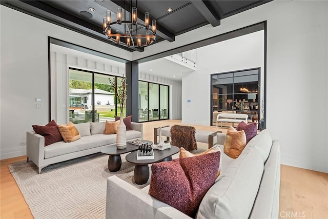 living room featuring a chandelier, wood finished floors, beam ceiling, and baseboards