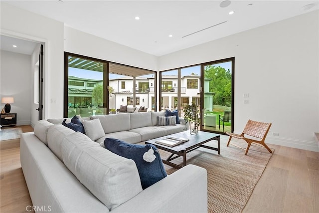 living area with light wood finished floors, recessed lighting, and baseboards