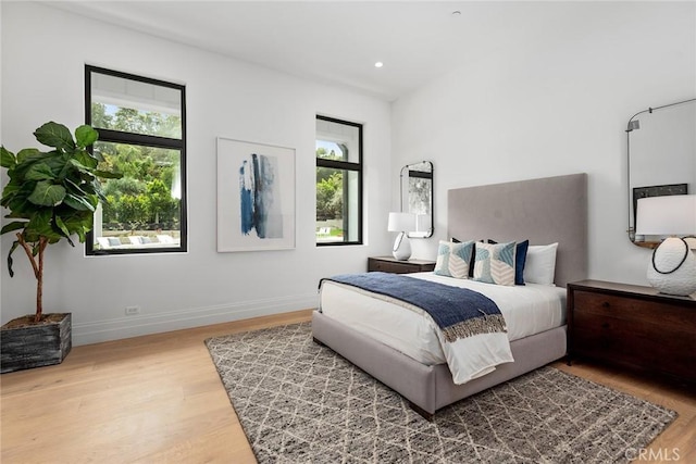 bedroom with wood finished floors, baseboards, and recessed lighting