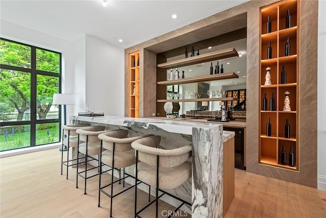 indoor wet bar with light wood finished floors, recessed lighting, and wine cooler