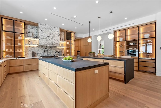 kitchen with a spacious island, dark countertops, light wood-style floors, light brown cabinetry, and recessed lighting