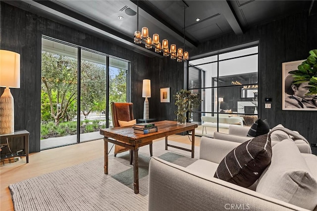 office space with wood finished floors, wood walls, a chandelier, coffered ceiling, and beam ceiling