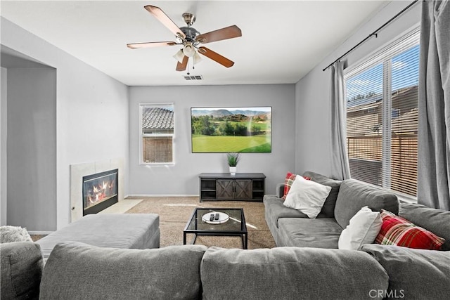 3260 Ivy Ct, Perris, CA 92571 - living room with carpet floors, a ceiling fan, a tiled fireplace, and baseboards