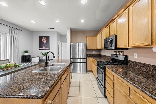3260 Ivy Ct, Perris, CA 92571 - kitchen with appliances with stainless steel finishes, a sink, recessed lighting, light tile patterned floors, and a kitchen island with sink