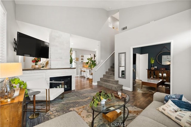 27903 Crown Court Cir Unit 92, Valencia, CA 91354 - living room featuring stairs, wood finished floors, high vaulted ceiling, baseboards, and a large fireplace